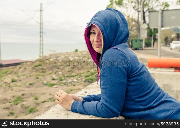 Women in hooded shirt outdoors looking at camera