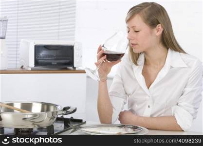 Women in kitchen with glass of wine