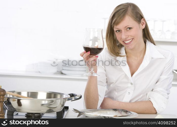 Women in kitchen with glass of wine