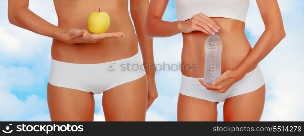 Women in lingerie with an apple and a bottle of water on a background of clouds