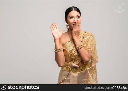 women is wearing Thai clothes and hand-made to cover her mouth.
