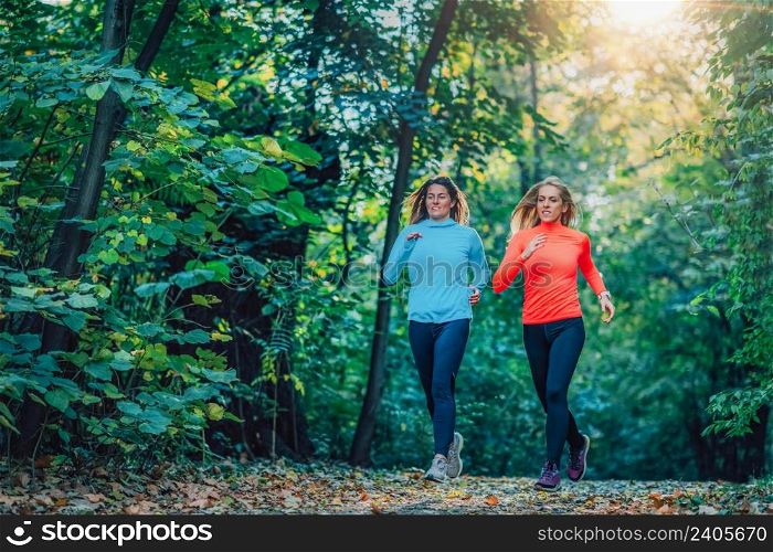Women Jogging Outdoors in a Public Park. Autumn, Fall.. Women Jogging Outdoors in a Public Park.