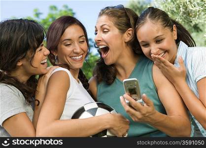 Women Laughing at Cell Phone Display