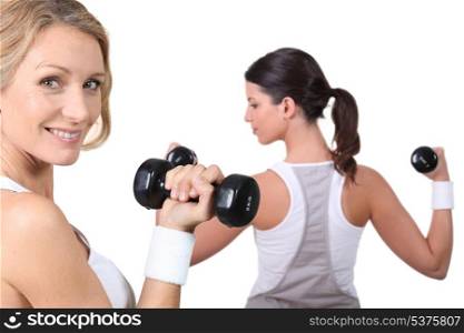 Women lifting weights together