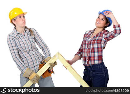Women lifting wooden triangle