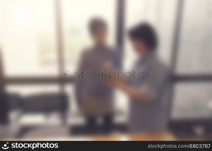 women look at mobile phone in meeting room, blur and vintage tone