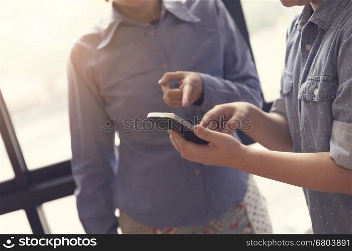 women look at mobile phone in meeting room, selective focus and vintage tone