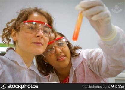 Women looking at liquid in test tube