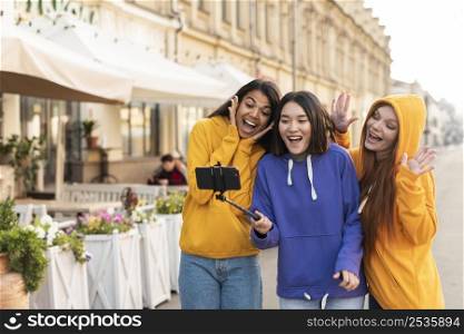 women making selfie using selfie stick
