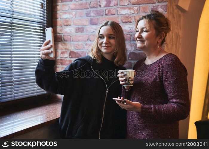 Women making video call on mobile phone. Taking selfie photo using smartphone. Connecting remotely with family and friends