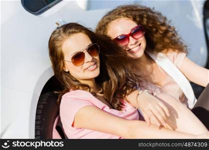 Women near car. Young pretty women sitting near white car at side of road
