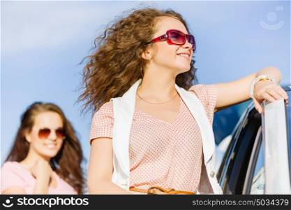 Women near car. Young pretty women standing near white car at side of road