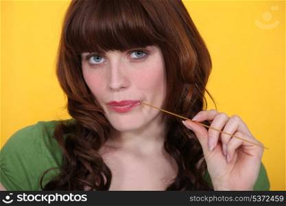 Women nibbling spaghetti