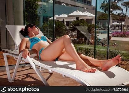 Women on a sun lounger beside the indoor pool