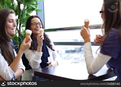 women on foreground licking ice cream
