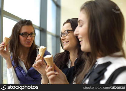 women on foreground licking ice cream