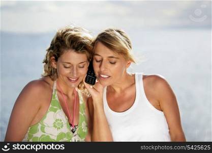 Women on holiday looking at their mobile phone