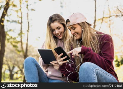 women outdoor park using mobiles