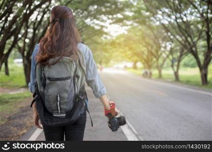 Women photographer holding a camera in the wild for take a photo of the tourist traveler