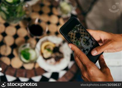 Women Photographing Raw Cake With Smart Phone in Vegetarian Restaurant.