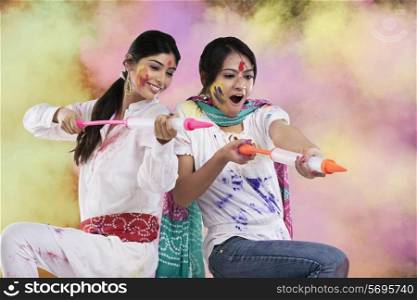 Women playing holi with pichkaris