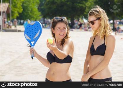 women playing tennis on the beach