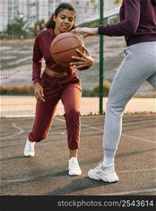 women playing together basketball outside