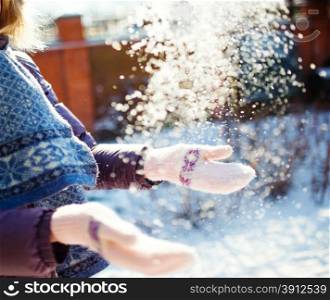 Women playing with snow in sunny winter day, small dof photo
