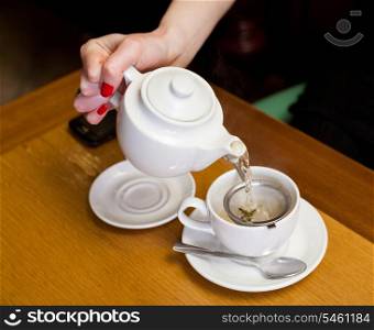 women pouring tea on a table