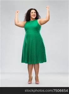 women power, strength and success concept - happy woman in red dress and making fist pump over grey background. happy woman in green dress showing women power
