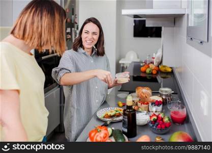 Women preparing healthy food in kitchen having fun, concept dieting nutrition.