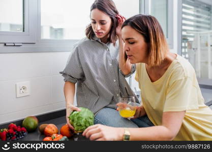 Women preparing healthy food playing with vegetables in kitchen having fun concept dieting nutrition.