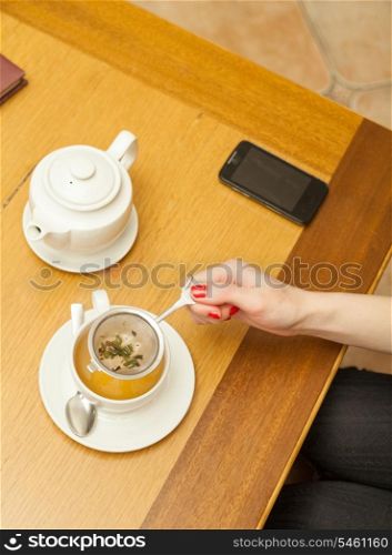 Women preparing herbal tea. Herbal tea on a table.