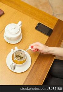 Women preparing herbal tea. Herbal tea on a table.
