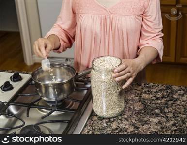 women preparing oatmeal for breakfast in kithen at range