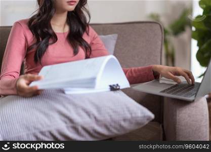 Women reading finance business document to typing data on laptop while working in lifestyle at home.