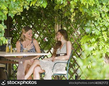 Women relaxing at table in a garden