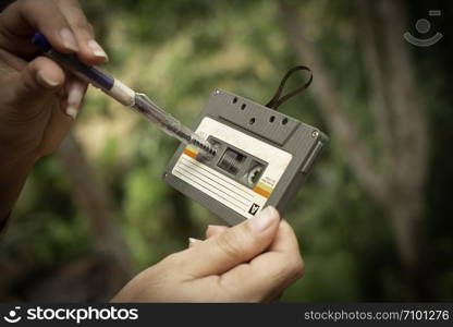 women rewind a cassette tape Vintage compact cassette on blur background, Close up set of old audio tapes, Ret