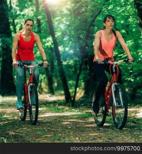 Women Riding Bikes Together in Park