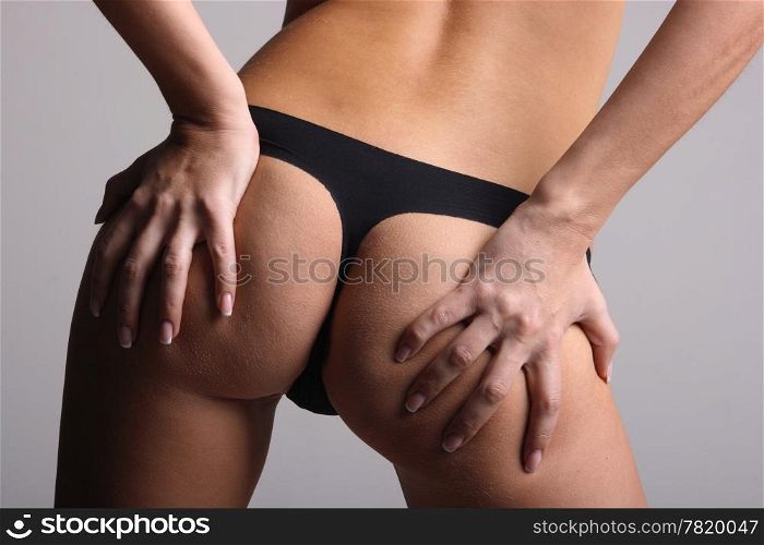 Women&rsquo;s buttocks in black lingerie on gray background