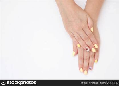 women's hands with a beautiful manicure with drawings of cakes and cherries on a light background