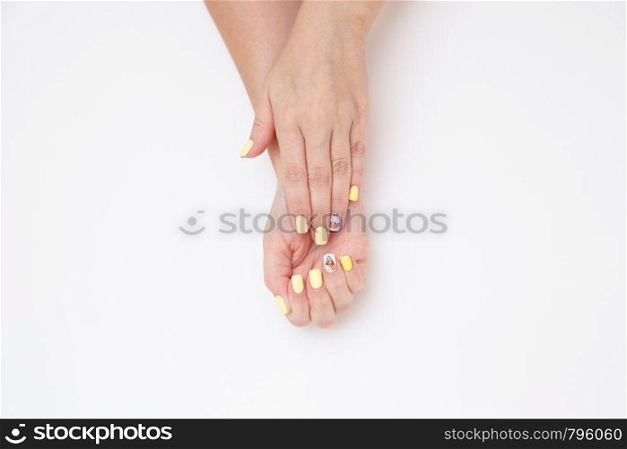 women's hands with a beautiful manicure with drawings of cakes and cherries on a light background