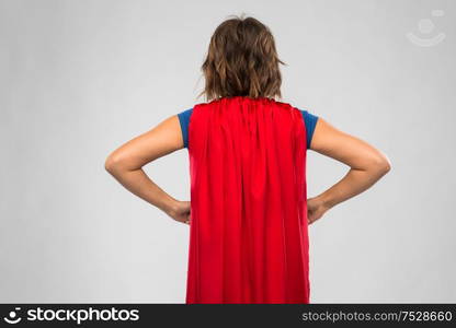 women&rsquo;s power and people concept - back view of young woman in red superhero cape over grey background. back view of young woman in red superhero cape