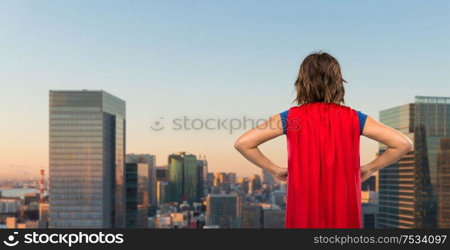 women&rsquo;s power and people concept - back view of young woman in red superhero cape over evening tokyo city skyscrapers background. woman in red superhero cape over tokyo city