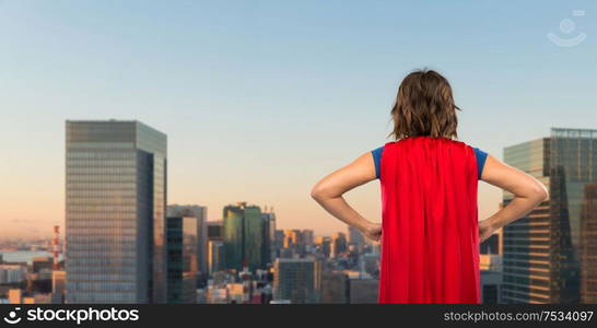 women&rsquo;s power and people concept - back view of young woman in red superhero cape over evening tokyo city skyscrapers background. woman in red superhero cape over tokyo city