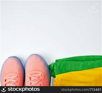 women's sportswear for active sports and pink sneakers on a white background, copy space