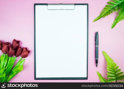 Women&rsquo;s stylish table. Workspace with blank white paper free space and pen in desk with flowers on pink pastel background for magazines, websites, media, Instagram. Flat lay, top view. Women&rsquo;s stylish table. Workspace with blank white paper free spa