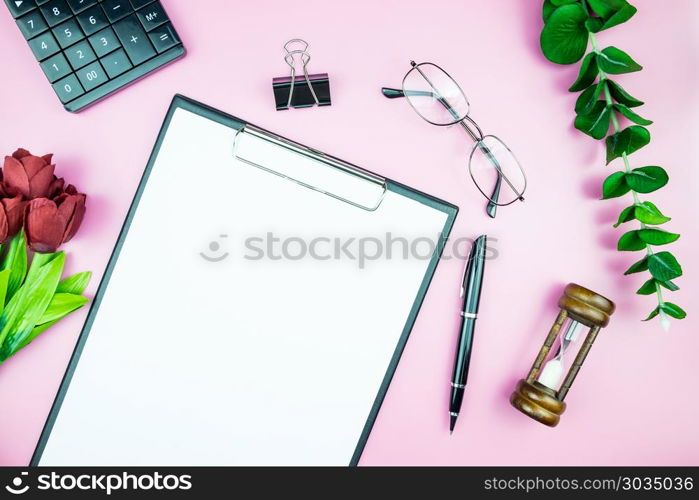Women&rsquo;s stylish table. Workspace with blank white paper free space and pen in desk with flowers on pink pastel background for magazines, websites, media, Instagram. Flat lay, top view. Women&rsquo;s stylish table. Workspace with blank white paper free spa