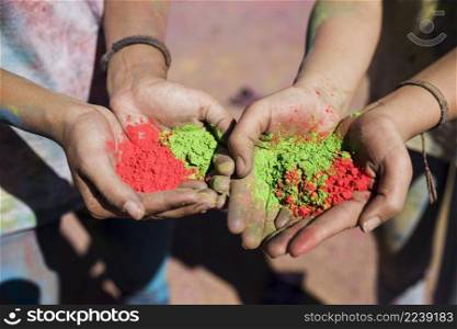 women s hand holding red green holi colors
