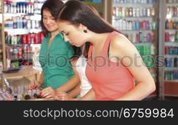 Women Shopping for Cosmetics, Testing Lip Gloss in Beauty Department